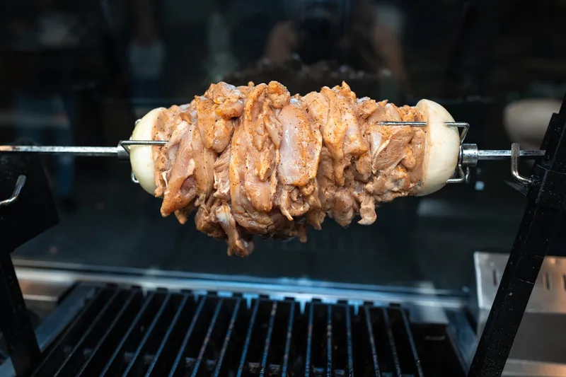Nahaufnahme der Gas- oder Elektro-Heizelemente eines Dönergrills, die das Fleisch gleichmäßig garen.