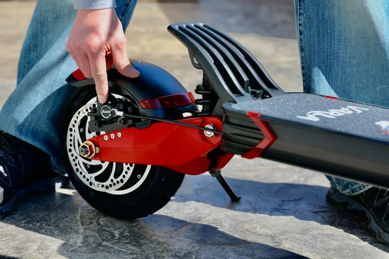 Detailaufnahme des Bremsmechanismus und des Rades eines E-Scooters für sicheres Fahren.