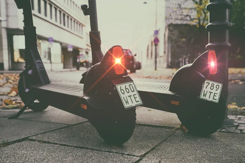 Ein E-Scooter ist sicher an einem Fahrradständer in einer belebten Fußgängerzone abgestellt.