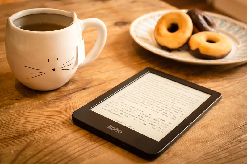 Gemütliche Leseszene mit einem eBook Reader auf einem Sofa oder Sessel im Wohnzimmer.