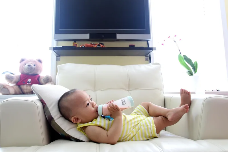 Eine gemütliche Babyecke mit abgepumpter Milch im Fläschchen, symbolisiert Flexibilität.