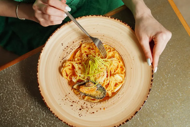 Eine appetitliche Schale frisch zubereiteter Pasta auf einem rustikalen Küchentisch, bereit zum Genießen.