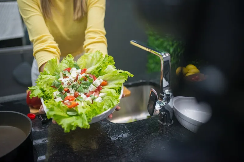Eine bunte Schüssel mit frisch geschnittenem Gemüse auf einer modernen Küchenarbeitsplatte.