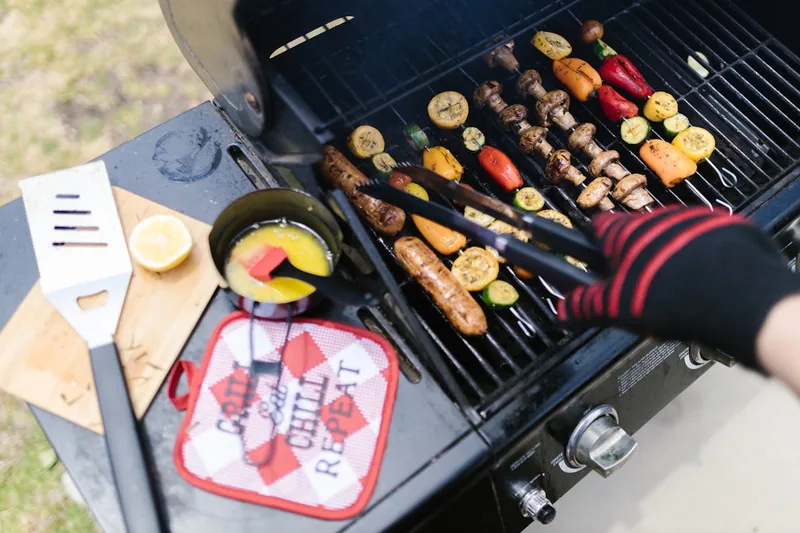 Eine gemütliche Outdoor-Szene mit fertig gegrilltem Essen und Freunden im Garten.