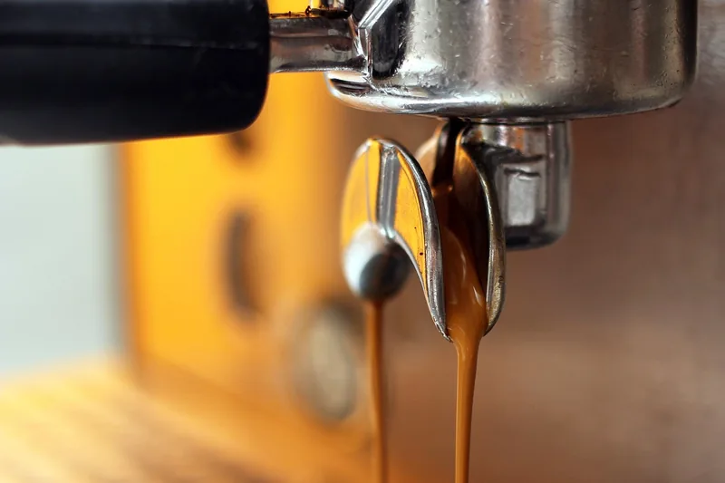 Hochwertige professionelle Espressomaschine aus Edelstahl im Produktstudio, sauber und scharf fokussiert.