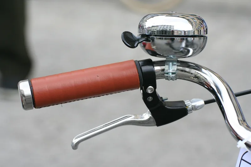 Nahaufnahme des Lenkers eines Fahrrad Cruisers mit komfortablen Ledergriffen und eleganter Glocke.