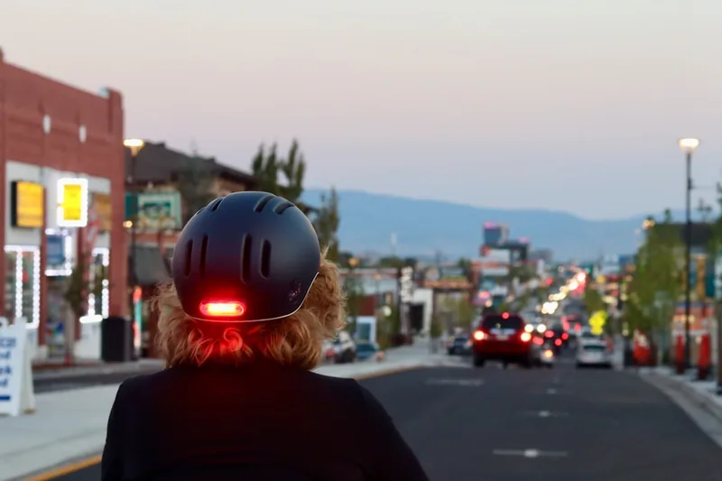 Eine Person trägt einen stylischen Fahrradhelm und fährt sicher durch die Stadt, aktive Nutzung.
