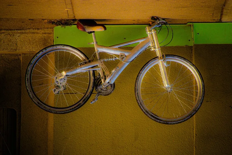 Eine Person hängt ein Mountainbike mit einem Fahrradlift platzsparend an der Garagendecke auf.