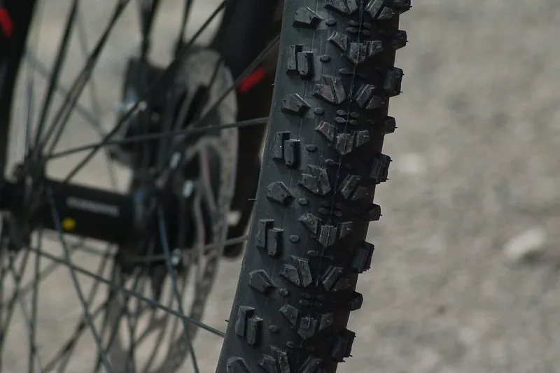 Eine Person stellt den Reifendruck eines 29-Zoll-Mountainbike-Reifens ein, zeigt die praktische Anwendung.