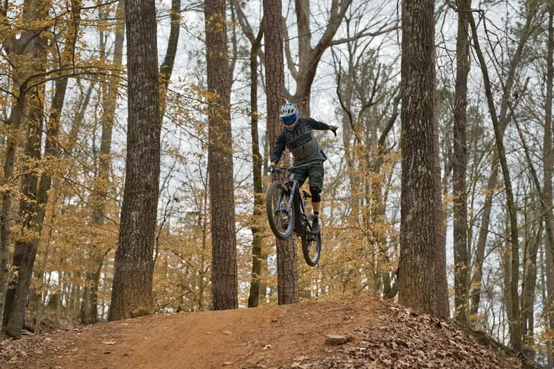 Ein Mountainbiker fährt mit 29-Zoll-Reifen einen Waldweg hinab, veranschaulicht Fahrperformance und Outdoor-Lifestyle.