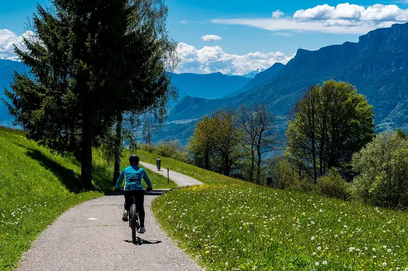 Atemberaubende Berglandschaft mit einem Radweg und einem Fahrrad, symbolisierend Outdoor-Abenteuer mit passendem Rucksack.