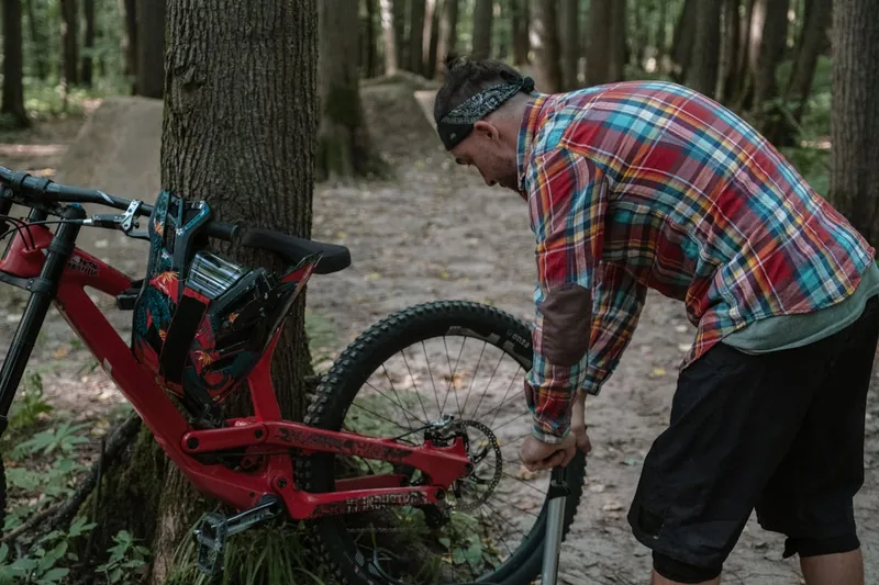 Hände einer Person beim Einsetzen eines 29 Zoll Fahrradschlauchs in einen Mountainbike-Reifen.