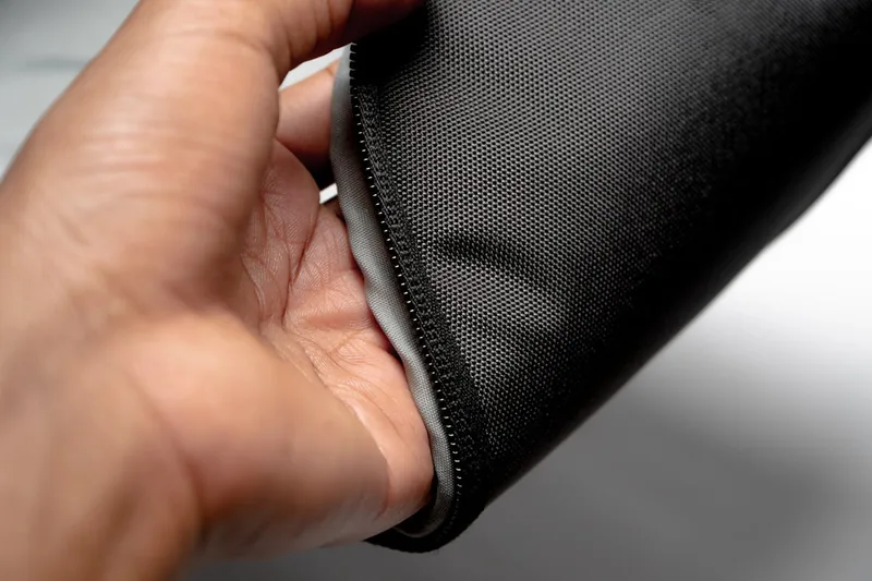 Nahaufnahme des strapazierfähigen Materials eines faltbaren Rucksacks mit Reißverschluss-Detail.