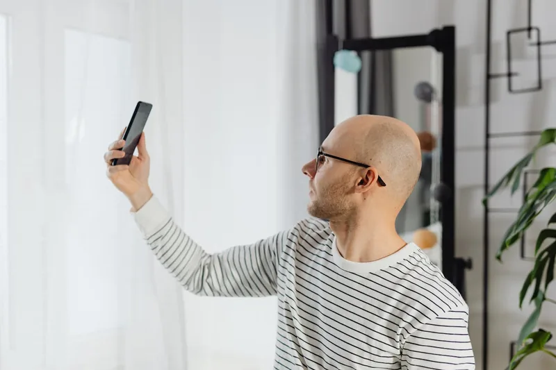 Eine Person bedient die moderne Funk-Video-Türsprechanlage am Display im Innenbereich des Hauses.