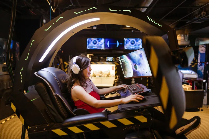 Ein stylischer Gaming-Bereich mit Monitor, Tastatur und einem hochwertigen Gaming-Stuhl im Hintergrund.