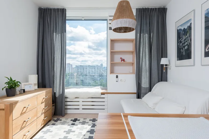 Ein stilvolles Wohnzimmer mit Vorhängen an einer Gardinenstange, die ein warmes Ambiente schafft.