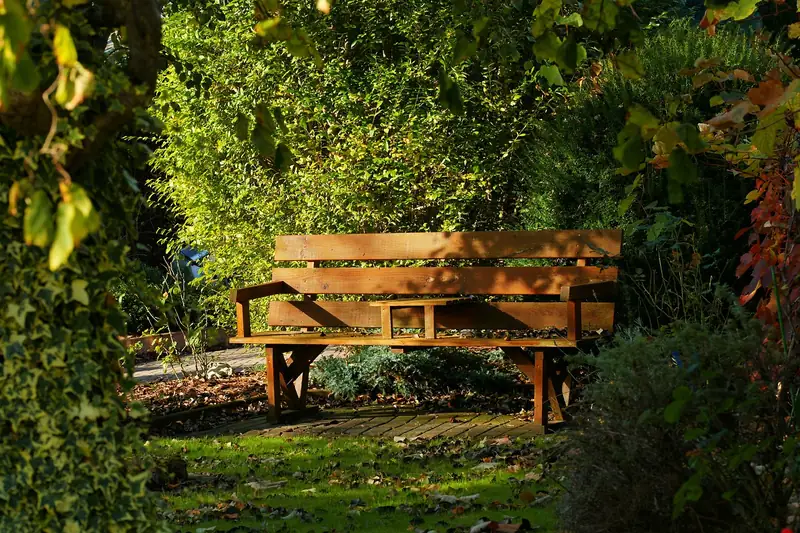 Eine einladende Gartenbank harmonisch eingebettet in eine grüne, naturnahe Gartenlandschaft.