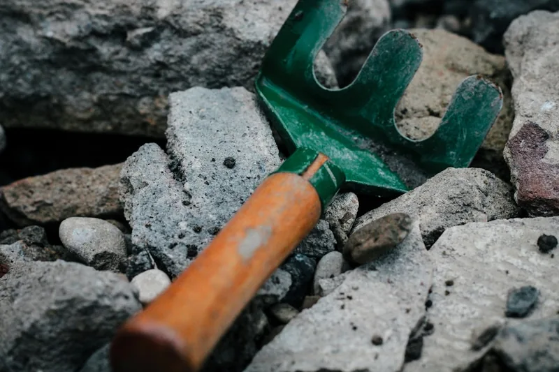 Nahaufnahme der stabilen Metallkrallen und des ergonomischen Griffs einer Gartenkralle.
