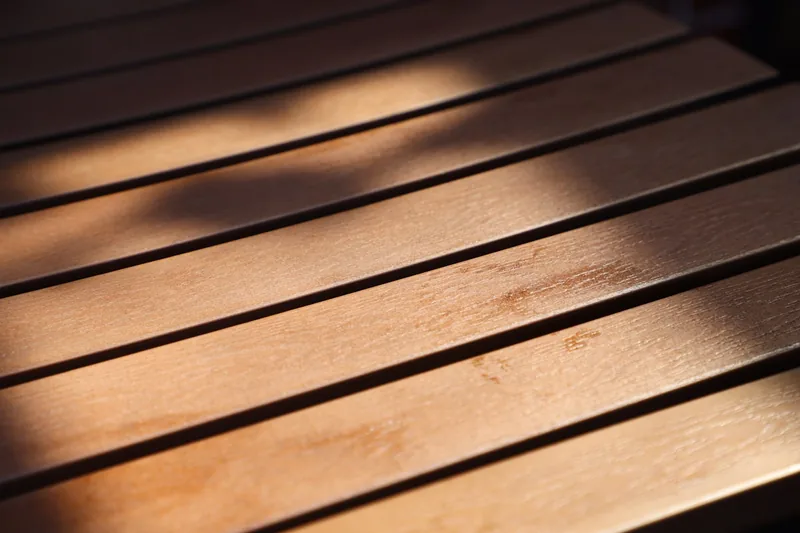 Nahaufnahme der Holzmaserung eines Gartentisches, die hochwertige Verarbeitung und Materialgüte zeigt.