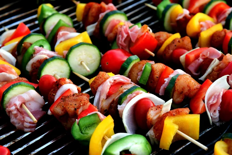 Nahaufnahme eines Gasgrillbrenners und des robusten Edelstahl-Grillrosts, fokussiert auf Materialqualität.