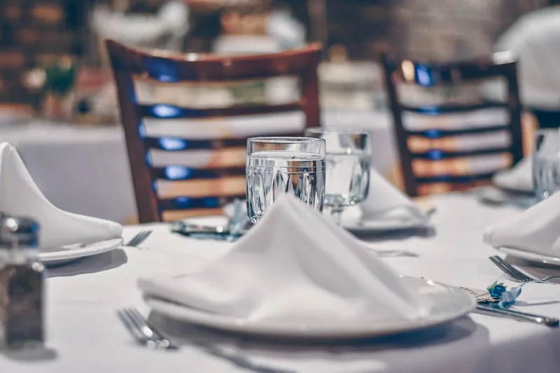 Elegante Restaurant-Szene mit gedecktem Tisch, Ambiente und Andeutung von Gastronomie-Equipment.