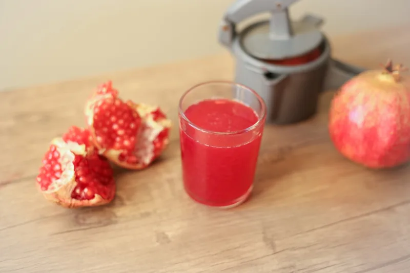 Ein schön gedeckter Frühstückstisch mit Granatapfelsaft und frischem Obst für Vitalität.