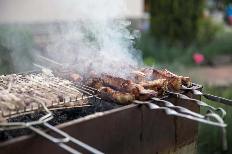 Professionelles Grillbesteck Set aus Edelstahl, elegant auf einem dunklen Hintergrund präsentiert.