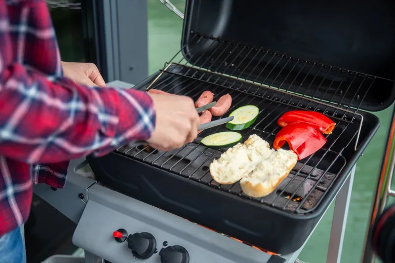 Gesellige Grillrunde im Garten mit Freunden und Familie, Fokus auf die entspannte Atmosphäre.