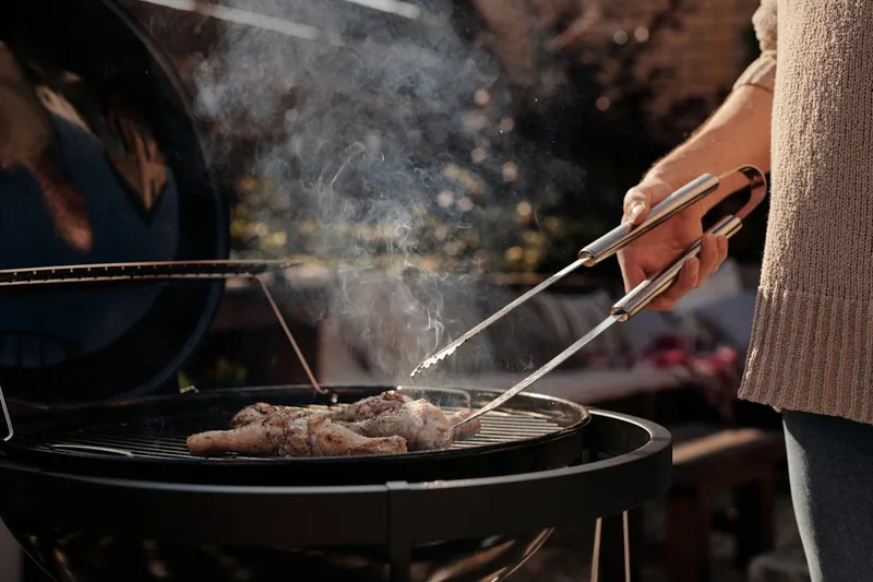 Eine schwarze antihaftbeschichtete BBQ Grillmatte liegt flach, bereit für den Einsatz.