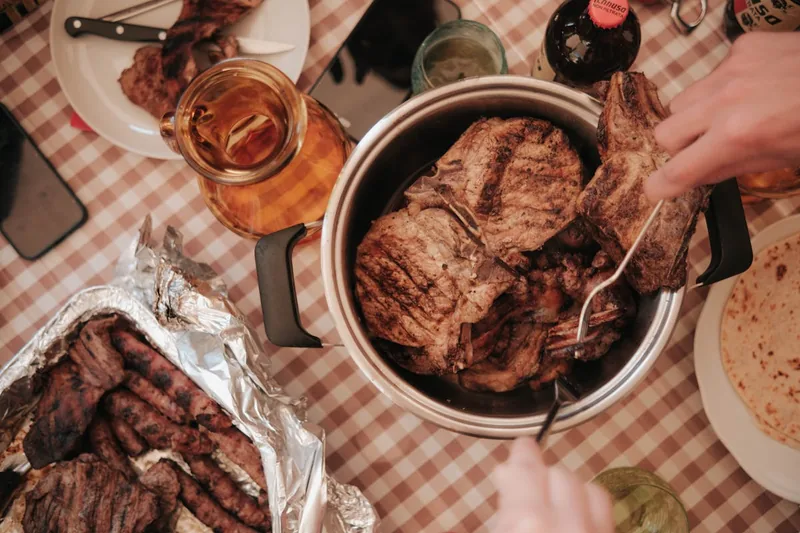 Ein gedeckter Gartentisch mit perfekt gegrilltem Fleisch und Gemüse, bereit zum Servieren.