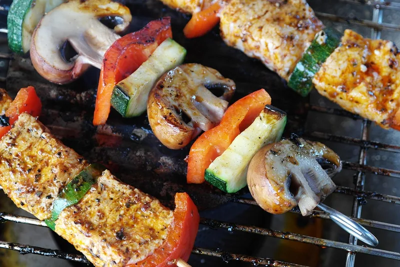 Gemütliche Outdoor-Grillszene im Garten mit Freunden und Familie, fokussiert auf die entspannte Atmosphäre.