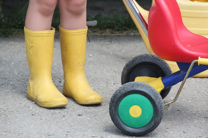 Ein Paar leuchtend gelbe Gummistiefel als Produktfoto vor neutralem, hellem Hintergrund.