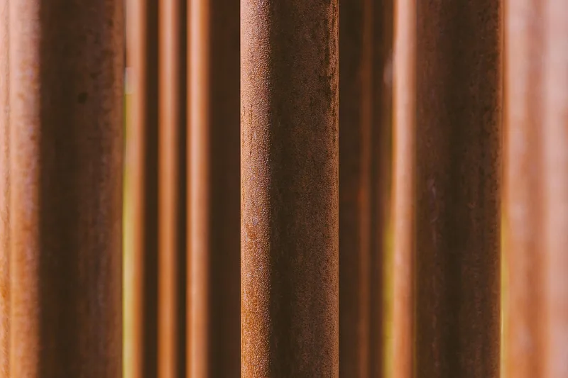 Nahaufnahme der rauen, eingebrannten Oberfläche einer Gusseisenpfanne, Fokus auf das Material.