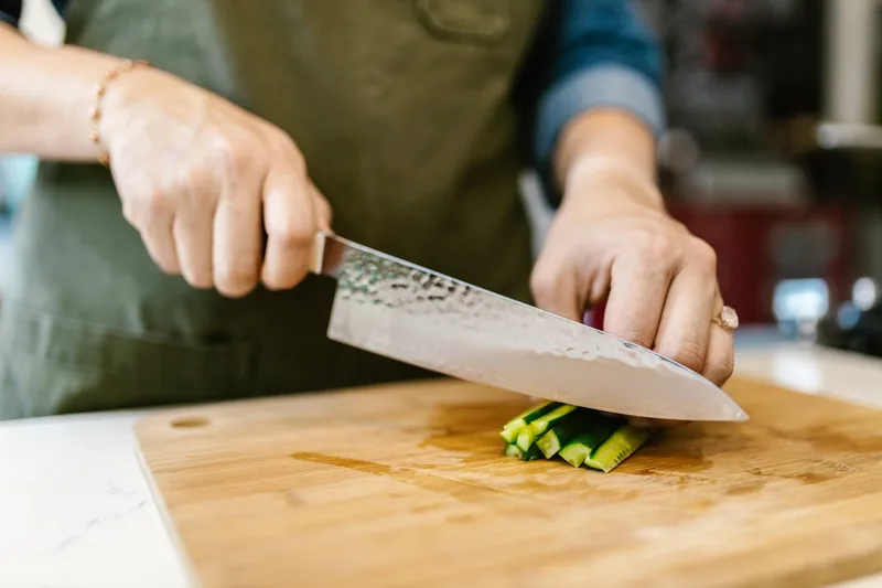 Nahaufnahme der geschmiedeten Damastklinge eines Gyuto Messers, die erstklassige Qualität zeigt.