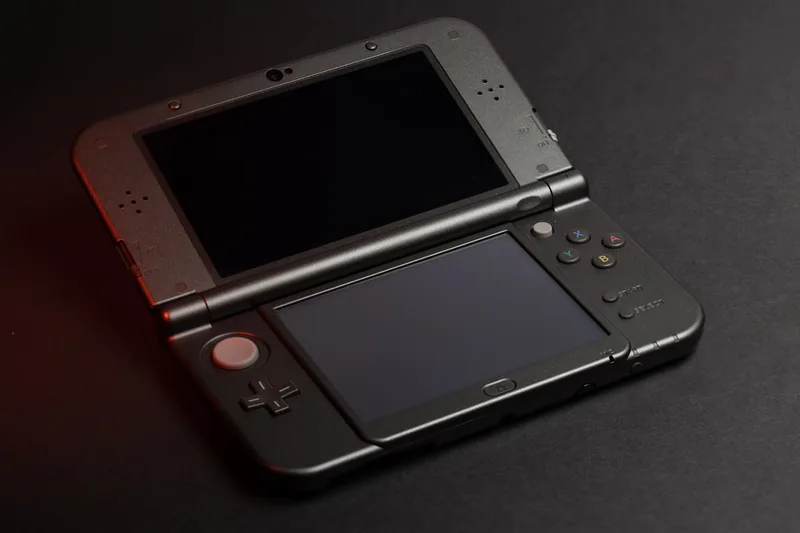 Eine moderne Handheld-Konsole in eleganter, schwarzer Ausführung, frontal vor neutralem Hintergrund.