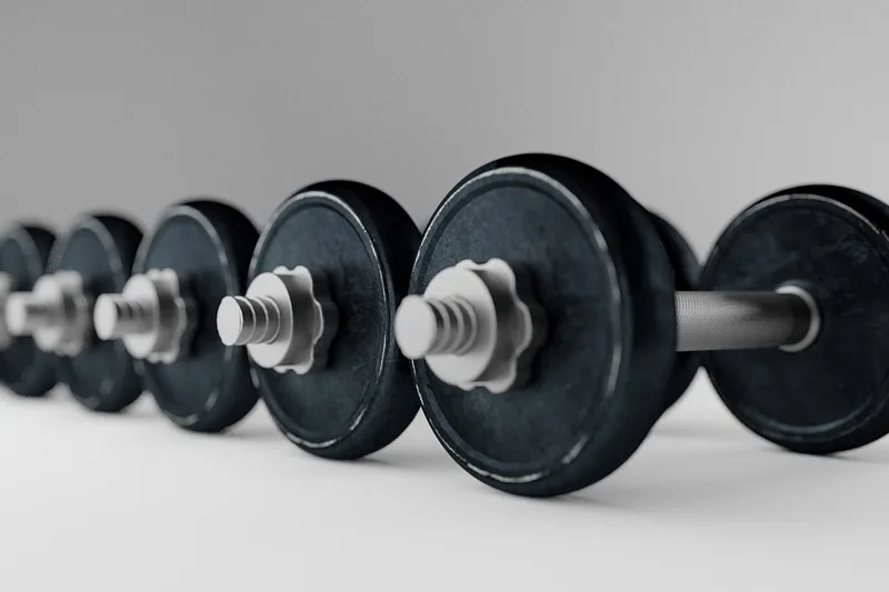 Eine Person beim Training, die Hantelscheiben auf eine Langhantel lädt, fokus auf sichere Handhabung.