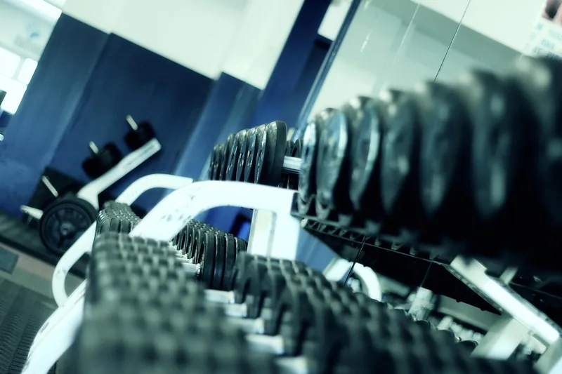 Ein aufgeräumter Heim-Fitnessbereich mit verschiedenen Hantelscheiben und Trainingsgeräten für eine motivierende Atmosphäre.