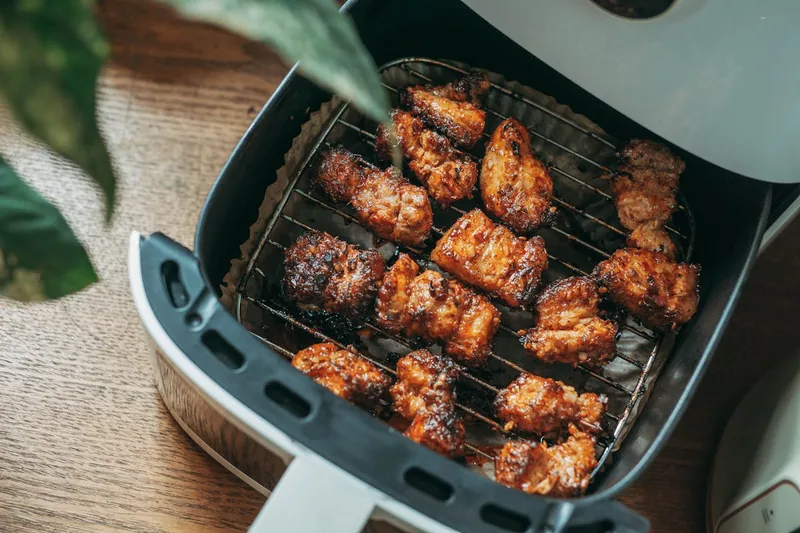 Moderne Heißluftfritteuse als Küchengerät, sauber und freigestellt.