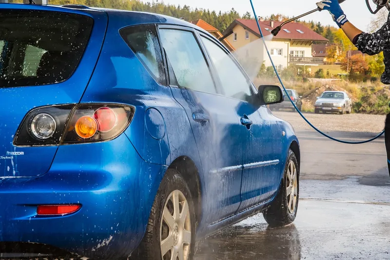 Ein glänzendes, frisch gewaschenes Auto steht auf einer sauberen Auffahrt, bereit zur Fahrt.