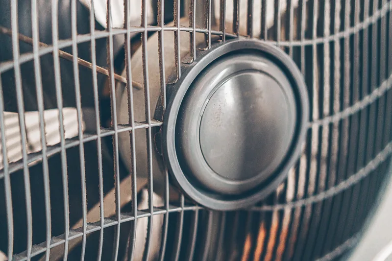 Nahaufnahme eines Ventilatorgitters mit sichtbaren Rotorblättern, die die hochwertige Verarbeitung hervorheben.