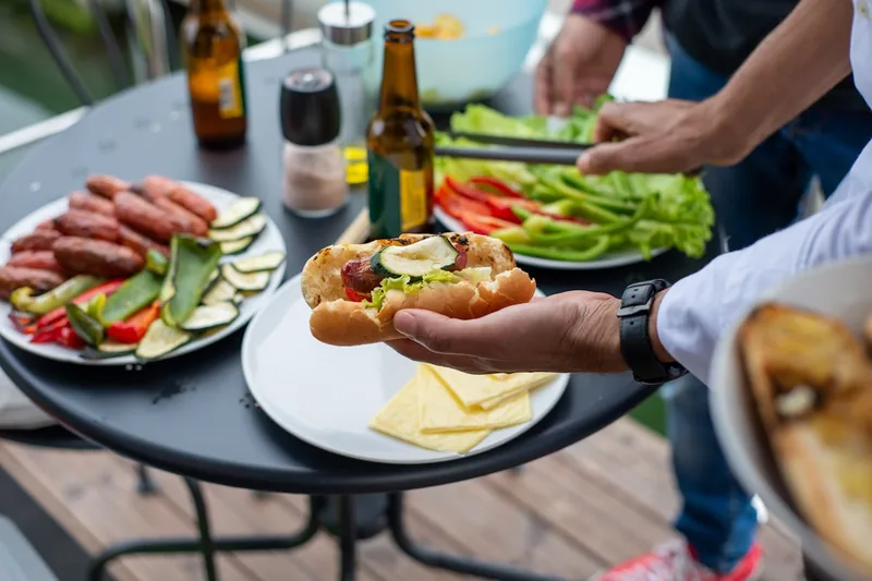 Ein reich gedeckter Tisch im Garten mit perfekt gegrilltem Fleisch und Gemüse nach dem Grillen.
