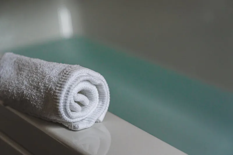 Helles, aufgeräumtes Badezimmerambiente mit frischen Handtüchern, das Hygiene und Wohlbefinden ausstrahlt.