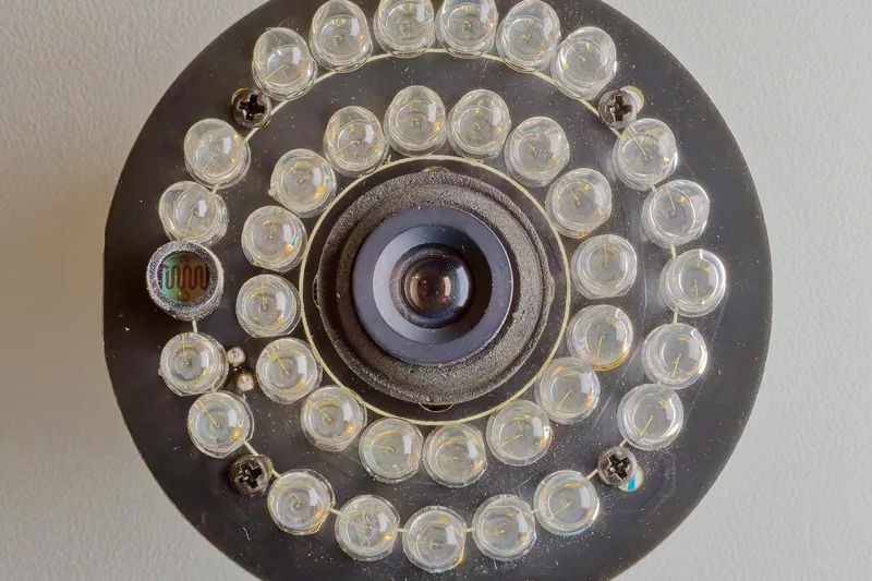 Nahaufnahme der Linse einer IP-Webcam, die Nachtsichtfunktion mit dezenten IR-LEDs zeigt.