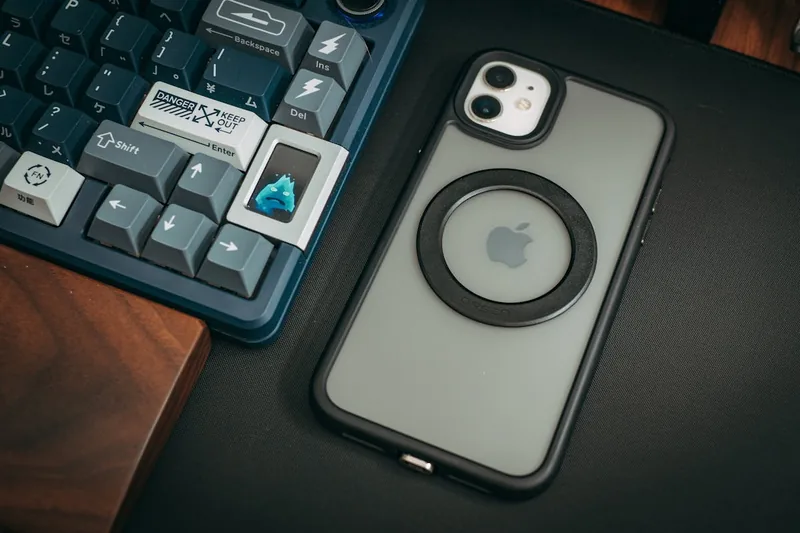 Ein aufgeräumter Schreibtisch mit einem iPhone und MagSafe-Accessoires, symbolisiert eine moderne Lade-Lösung.
