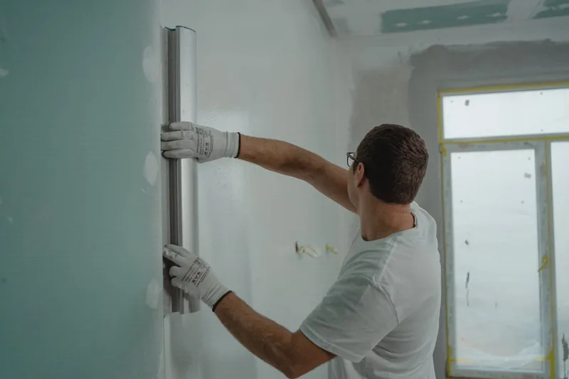Perfekt geglättete, makellose Wandfläche in einem modernen Raum, das Ergebnis präziser Spachtelarbeit.