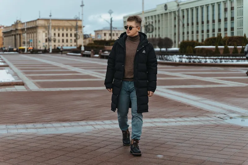 Ein Mann trägt eine moderne Jeanshose und spaziert durch eine urbane Umgebung, was den Komfort und Stil im Alltag unterstreicht.