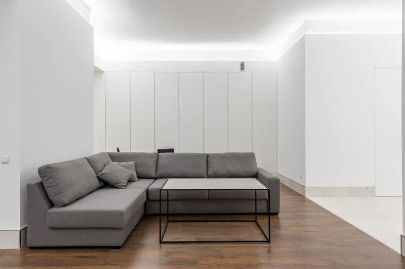Ein sauberer, moderner Wohnbereich mit hellem Sofa, der das Ergebnis effektiver Reinigung zeigt.