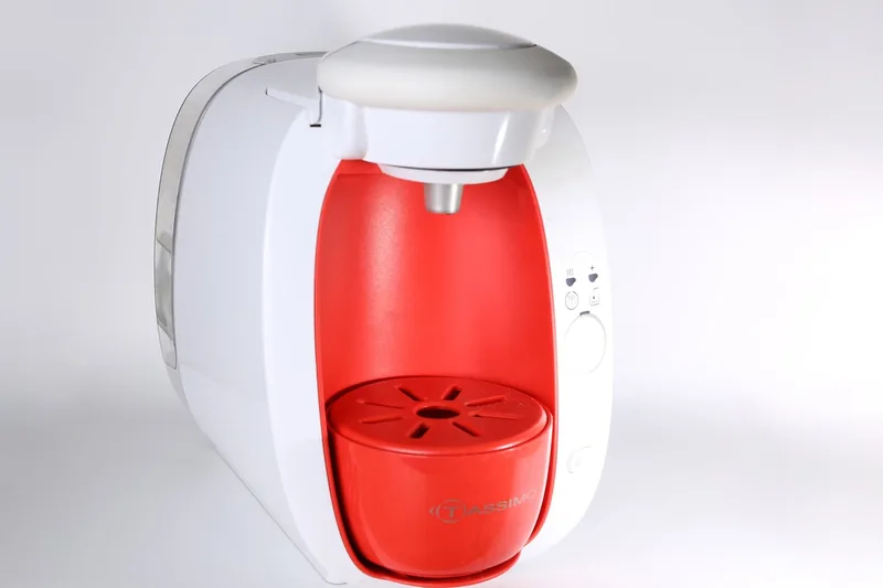Elegante weiße Kaffeemaschine von vorne, isoliert auf hellem Hintergrund, bereit für den Einsatz.
