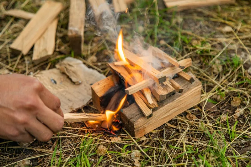 Sauber gestapelte Kienspan-Sticks, eine natürliche Anzündhilfe, auf einem rustikalen Holzuntergrund.