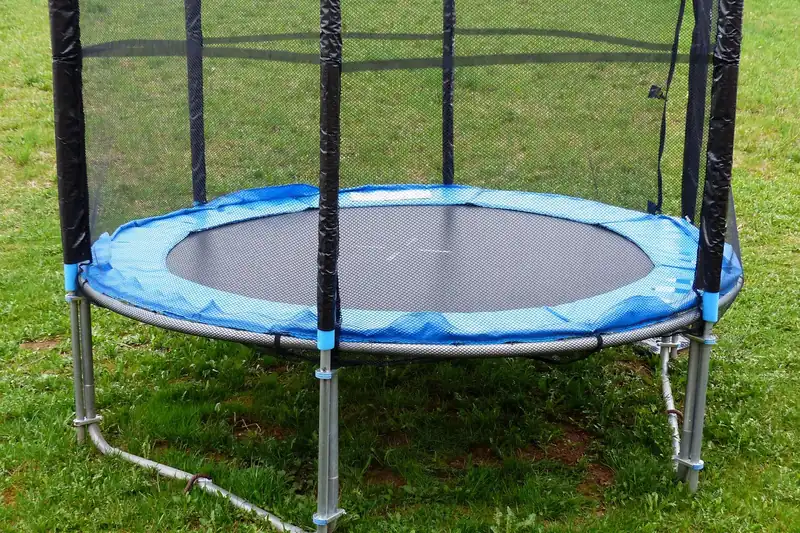 Idyllische Gartenszene mit einem Kindertrampolin, das zum Spielen im Freien einlädt.
